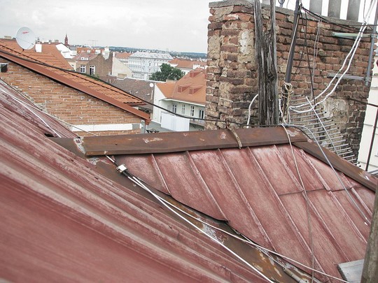 Stará hliníková střecha, do které zatéká. Chybí oplechování komínů a jednotlivá úžlabí střechy a další  místa potřebují rekonstrukci